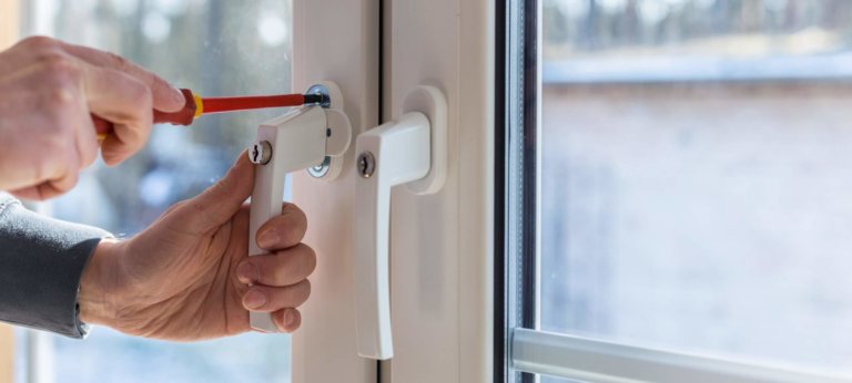 Mitarbeiter von Müller Fensterbau befestigt abschließbare Fenstergriffe