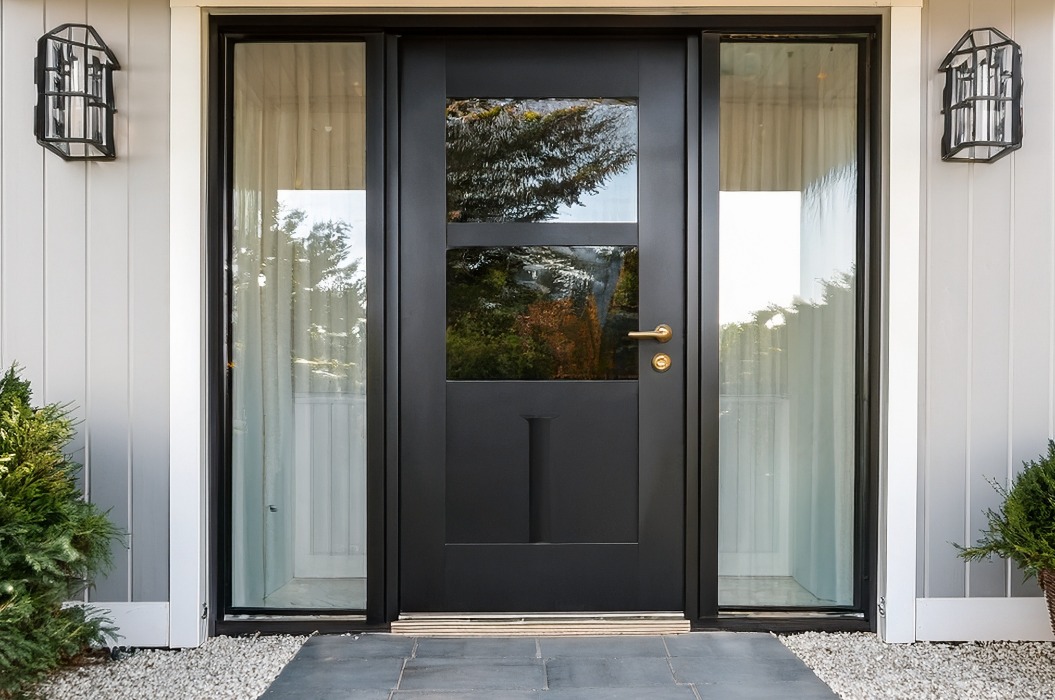 Dieser stilvolle, moderne Bauernhofeingang zeigt eine Tür mit Aluminiumrahmen mit glattem schwarzem Glas, weißen Wänden, Holzakzenten und schön angeordneten hellgrauen Bodenfliesen